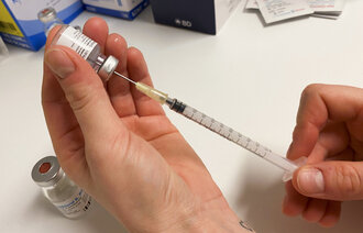 Bildet viser en sprøyte med covid-19-vaksine som blir trukket opp.