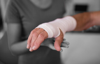 Bildet viser en eldre person med skadet hånd.