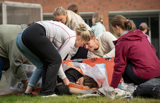 Bildet viser en gruppe studenter under en førstehjelpsøvelse