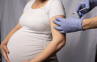 Bildet viser en gravid kvinne som blir vaksinert.