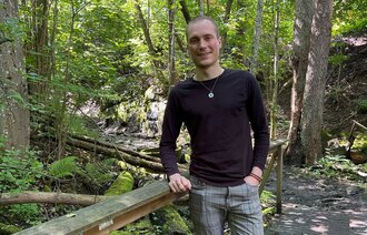 Bildet viser Daniel Tørresvoll Stabu på en bro i skogen