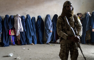Bilde av soldat foran rekke av kvinner i Afghanistan
