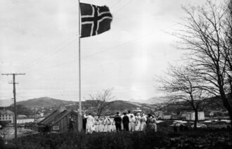 Bilde viser sykesøstre som heise det norske flagget på frigjøringsdagen
