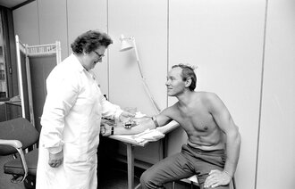 Bilde viser Sykepleier Ester Andersen tar blodprøve av Roger Vilbo.