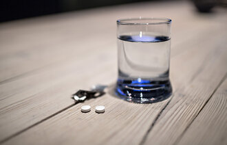 Illustrasjonsfoto. Tabletter ved glass