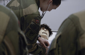 Bildet viser militært personell som undersøker simuleringsdukke