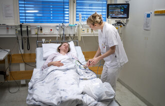 Bildet viser en kvinnelig sykepleier og en kvinnelig pasient