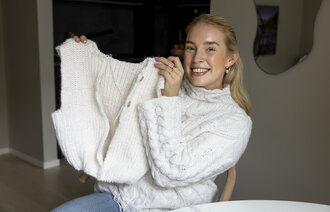 Bildet viser Maria Tessem som holder opp en påbegynt vest.