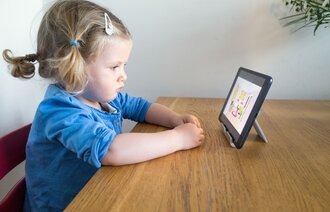 Småbarn og skjerm Småbarn som ser på en Ipad-skjerm