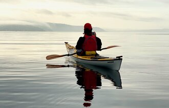 Bildet viser en mann som padler kajakk og er i fysisk aktivitet
