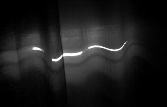 Bildet viser lys utenfra som slipper gjennom soveromsgardiner.