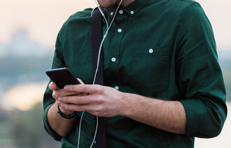 Bildet viser en mann som leser på mobilen.