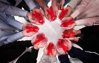 hender som holder røde sløyfer bildet viser hender som holder røde sløyfer