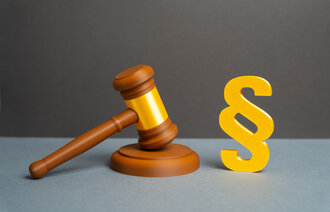 Bildet viser en dommerklubbe og en paragraf