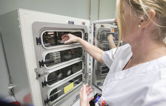 Bildet viser en sykepleier og en inkubator.