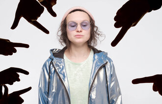 Bildet viser et bilde av en unge jente som står rett opp og ned mens fingre peker på henne.