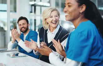 Bildet viser kollegaer som anerkjenner hverandres innsats