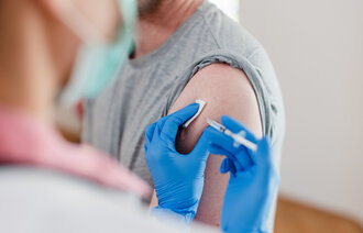 Bildet viser en mann som får vaksine