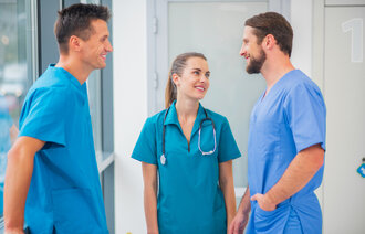 Bildet viser tre sykepleier som står og prater sammen