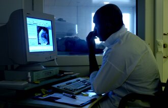 Bildet viser en radiolog som ser på røntgen Bildet viser en radiolog som ser på røntgen