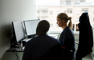 Bildet viser en lege som ser på en PC-skjerm.