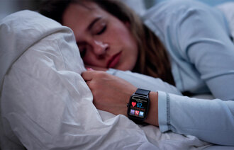 Kvinne som sover med smartklokke. Bildet viser en kvinne som sover med smartklokke.