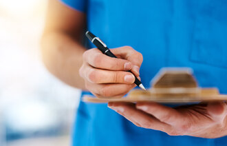 Bildet viser hender som skriver på en flate.