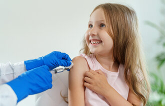 Bildet viser en liten jente som får vaksine