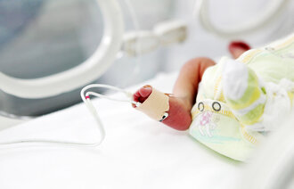 Bildet viser bena til en baby som har pulsmetningsmåler på.