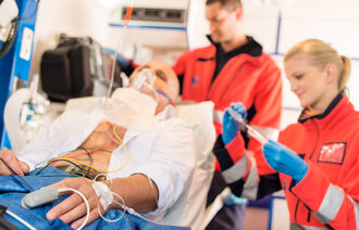 bildet viser ambulansepersonell med pasient
