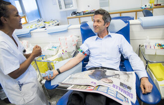 Bildet viser Christian Clemm som gir blod og bioingeniør Messeret Abeje Worku.