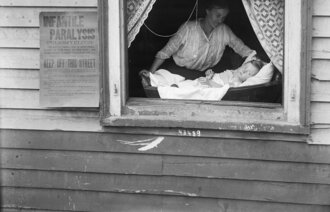 Bildet viser kvinne og barn i et vindu under polioepidemien i USA i 1916.
