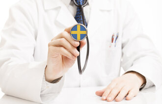 Lege med stetoskop med svensk flagg