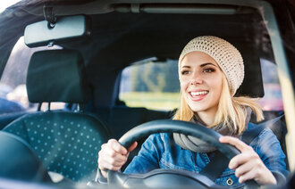 Bildet viser ung kvinne som kjører bil