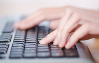 Bildet viser hender som skriver på et tastatur.