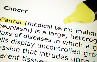 Bildet viser en bokside med definisjon av cancer.