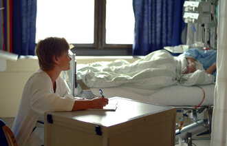 Bildet viser en sykepleier som skriver dagbok for en pasient