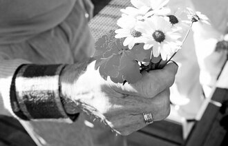 Eldre kvinne holder en blomsterbukett