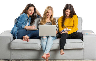 Bildet viser tre unge kvinner som sitter i en sofa med PC og kladdeblokker.