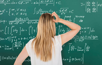 Student som står foran en tavle med matematiske formler