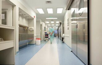 Helsepersonell som går bortover i en sykehuskorridor.