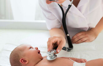 Bildet viser et spedbarn som blir undersøkt med et stetoskop 