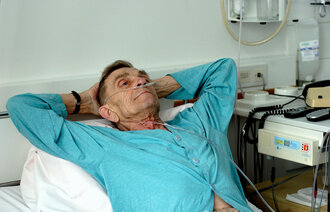 Bildet viser en eldre mann med kols som ligger i en sykehusseng.