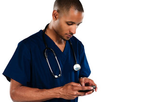 Mannlig lege/sykepleier kikker på mobilen.