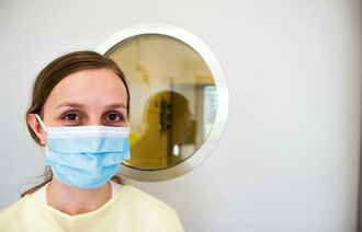 Bildet viser Siri Berg Flesvig i gul smittedrakt og med munnbind.