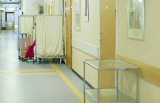 Pasient som ligger ute i korridor på sykehus