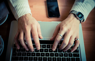 Illustrasjonsfoto av hender på et PC-tastatur