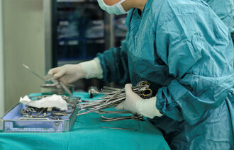 Bildet viser en sykepleier som klargjør instrumentbordet før en operasjon.