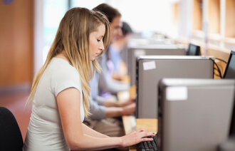 Bildet viser studenter som sitter foran PC-er på lesesalen.