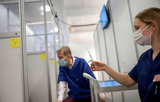 Bildet viser sykepleiere som gjør klart til å sette koronavaksine.